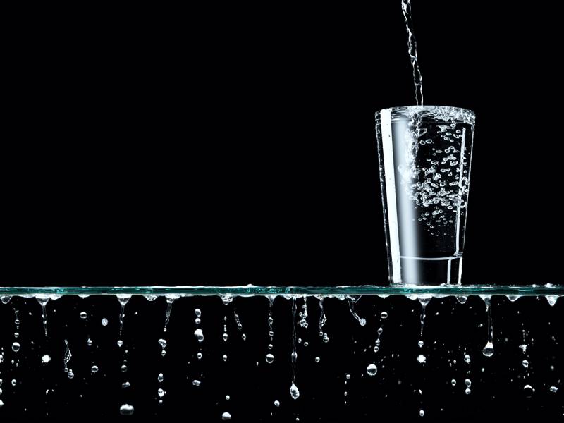 water overfiling a glass and overflowing the glass shelf it's ons