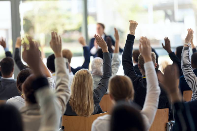 hands raised in a room full of people