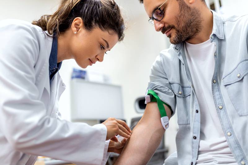 nurse drawing blood from patient